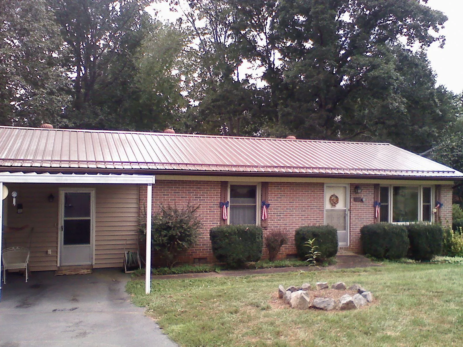 Bronze metal roof and carport on a brick ranch home — Roof Repair work by our crew in Matthews